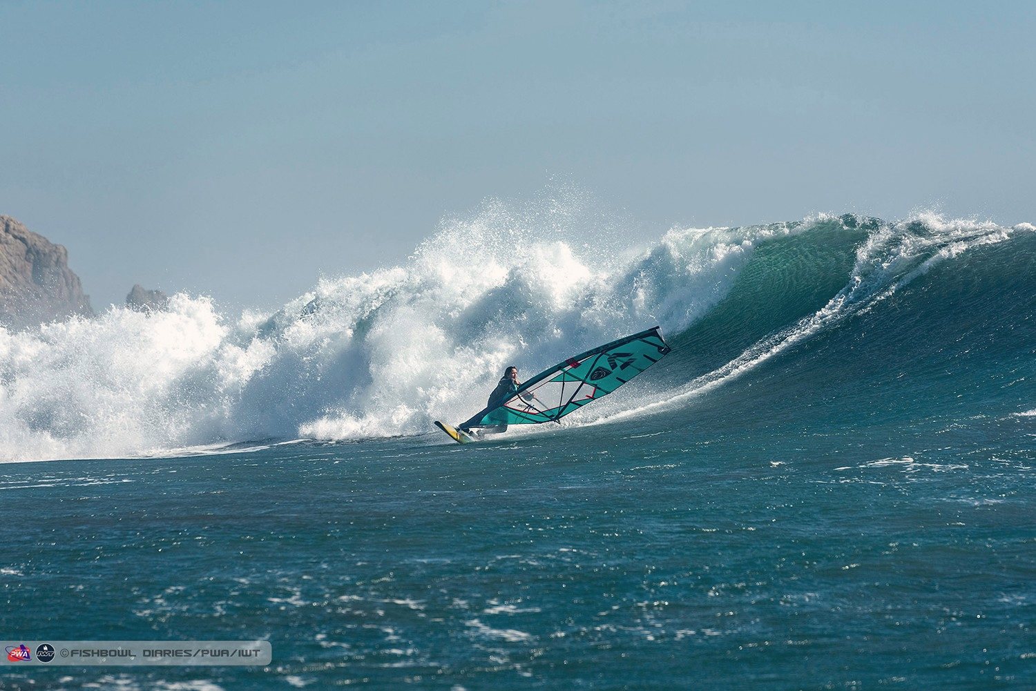 A windsurfer dropping down a big wave at the Chile World Cup